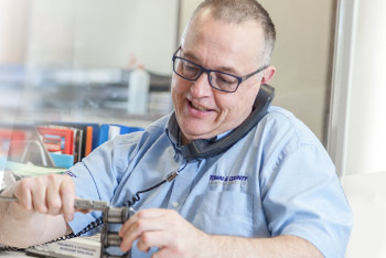 Man measuring chain whilst talking on the phone